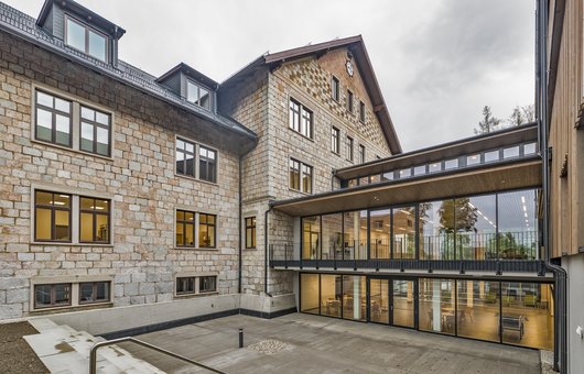 Denkmalgeschützte Jagdschloss Verglaste Gänge verbinden das denkmalgeschützte Jagdschloss mit den neu errichteten Schul- und Wohngebäuden.