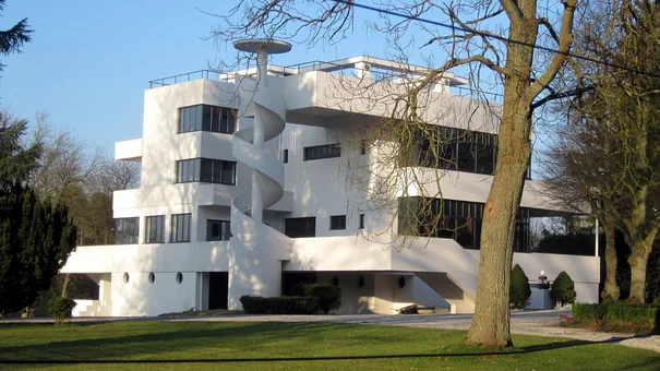 White villa with panelled spiral staircase outside