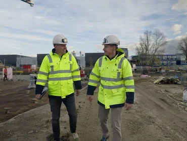 Bauleiter auf der Baustelle reden miteinander