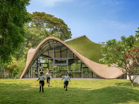 Gebäude mit geschwungenem, bis auf den Boden reichendem und begrüntem Dach