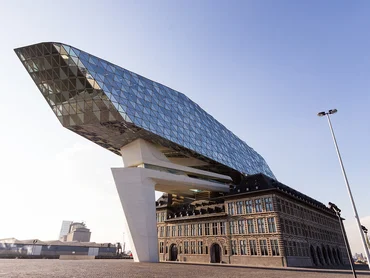 Altes Gebäude mit modernem Bau mit Glasfassade darüber