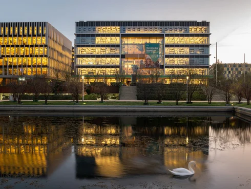 quaderförmiges Gebäude, davor Wasser mit einem Schwan