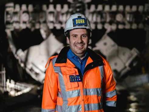 Porträt eines Bauarbeiters vor einer Tunnelbohrmaschine