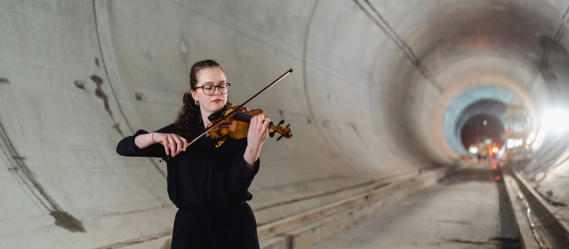 Woman plays violin in a tunnel