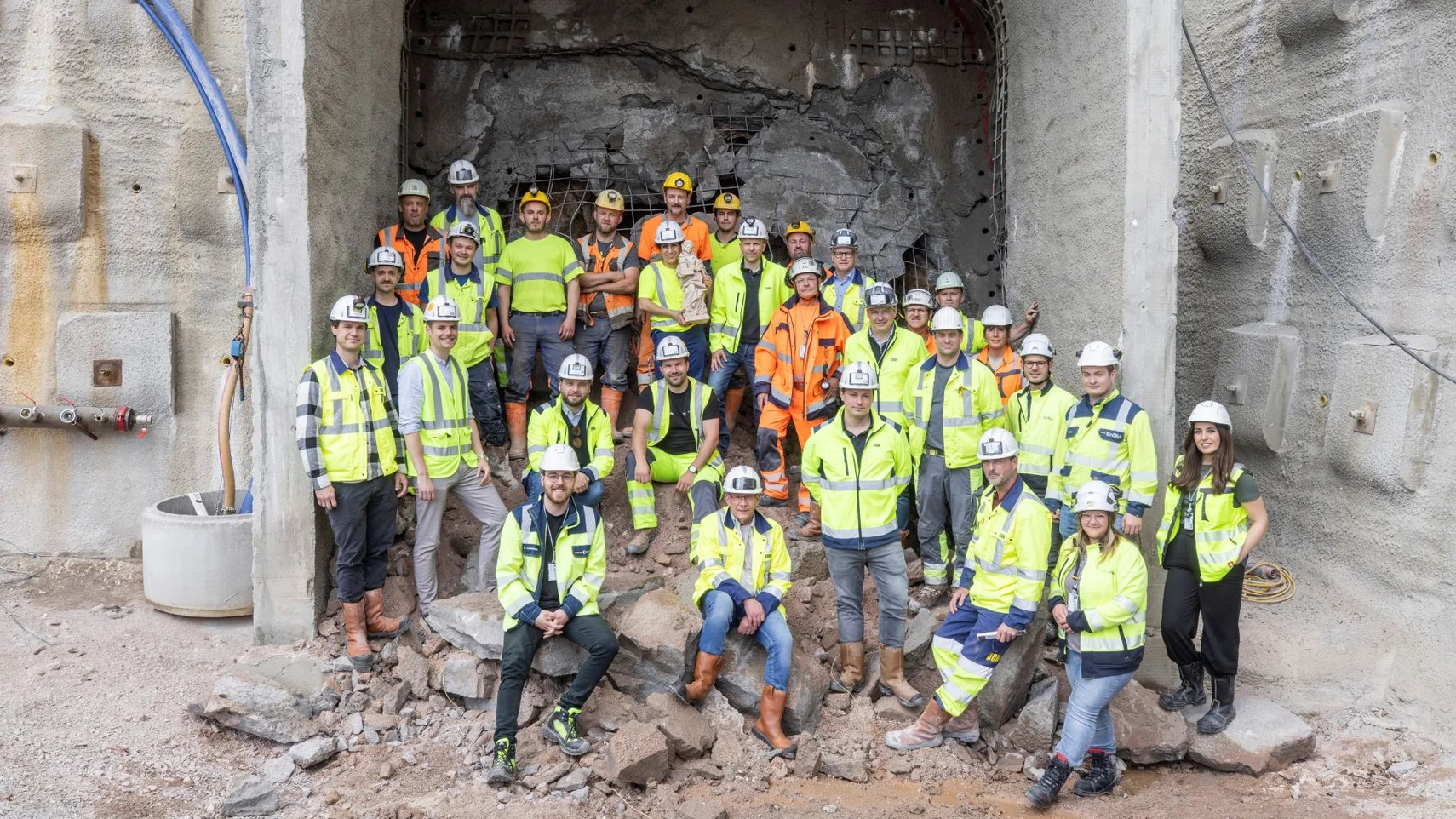 Gruppe von Bauarbeiterinnen und Bauarbeitern bei einem Tunneldurchbruch