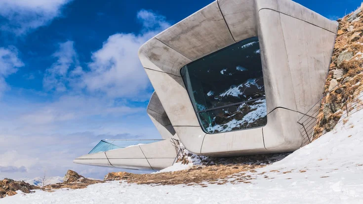 Großes rechteckiges Fenster in einem Berg mit Schnee im Vordergrund