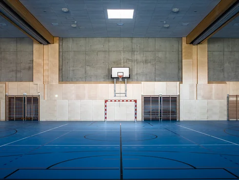 Turnsaal mit blauem Boden und Basketballkorb