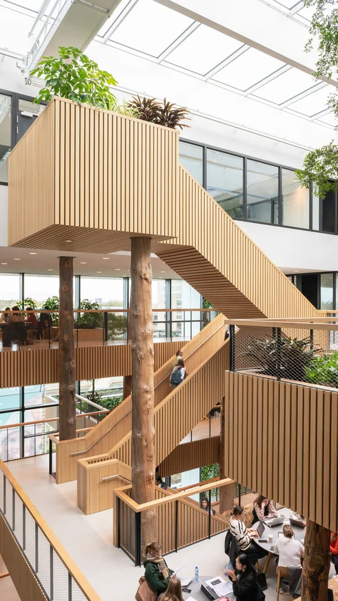 Mehrstöckiger Innenraum mit Dachfenstern und Treppen mit Holzgeländern