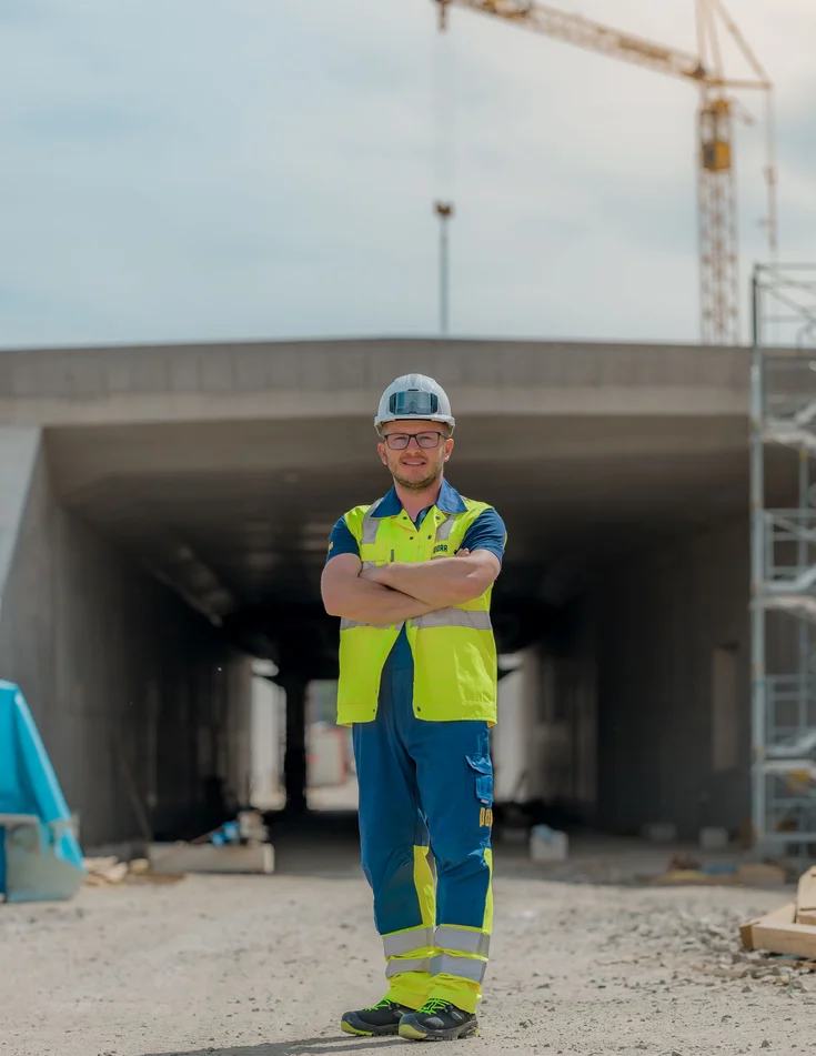 Worker on a construction site with a crane in the background