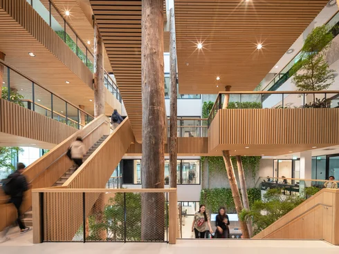 Mehrstöckiger Innenraum mit Dachfenstern und Treppen mit Holzgeländern