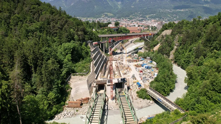Baustelle mit rotem Kran in einer Schlucht