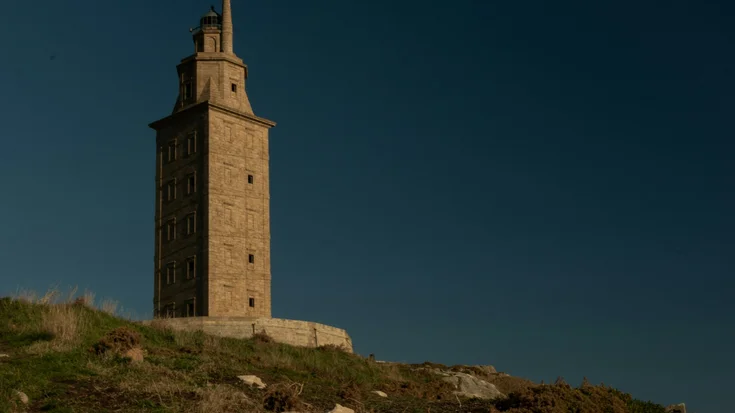antique, brown lighthouse on a hill