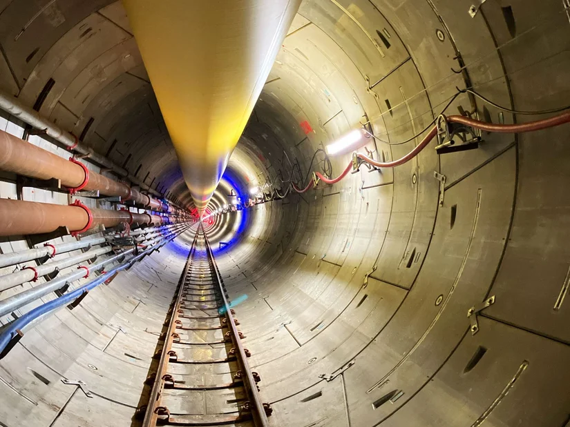 illuminated tunnel with rails and pipes