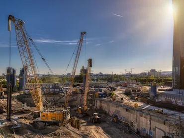 Baugrube mit Baugeräten, rechts der DC Tower